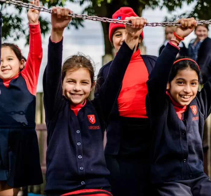 Group of junior school girls smiling and playing in playground